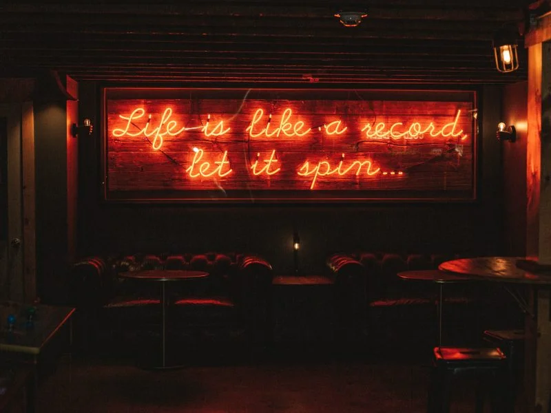 Life is like a record, let it spin — neon sign in The Vinyl Room lounge